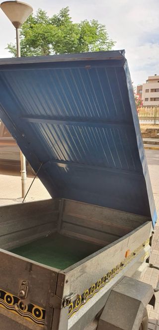 un remolque basculante con capota y vaca