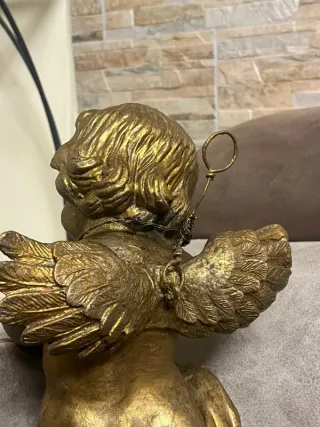 Puttino in metallo con occhi in vetro