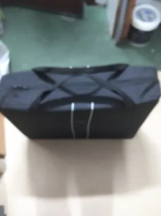 Cuna de viaje plegable con colchón y maleta.