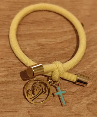 Pulsera amarilla con colgantes de cruz y virgen