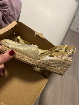 Cuñas doradas de esparto con lazada.