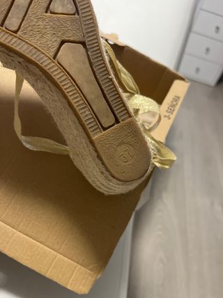 Cuñas doradas de esparto con lazada.