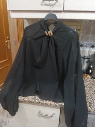 Blusa negra elegante con detalle dorado