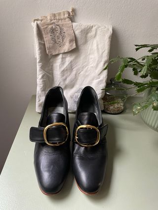 Zapatos de mujer con hebilla dorada. Recreación