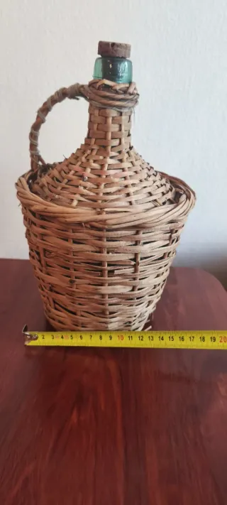 Botella antigua de vidrio con cestería