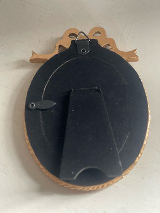 Cornice ovale dorata con fiocco in resina