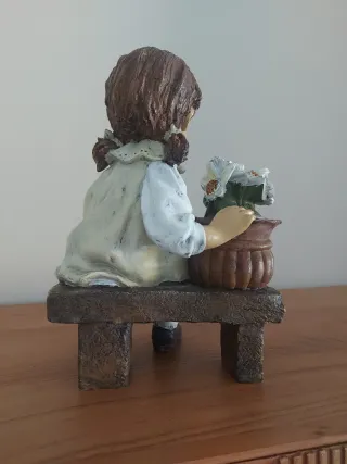 Figura niña sentada en un banco