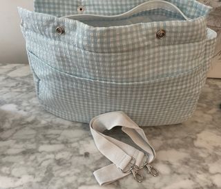Bolsa para carrito de bebé a cuadros.