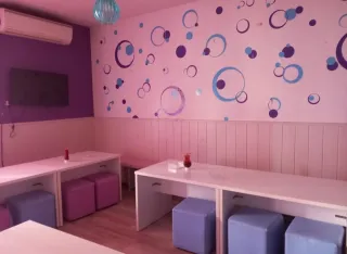 Mesas blancas y puffs morados/azules