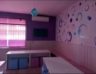 Mesas blancas y puffs morados/azules