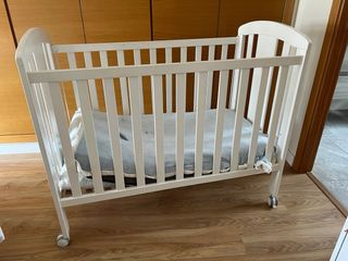 Cuna de bebé blanca con ruedas