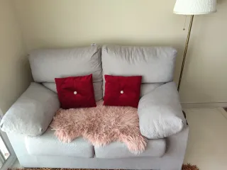 Sofá gris con cojines rojos