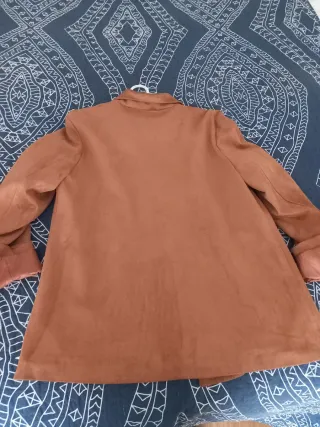 Chaleco negro y chaqueta ante marrón