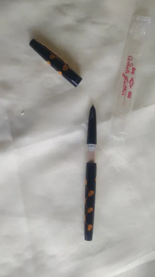 Penna stilografica nera con decorazioni arancioni