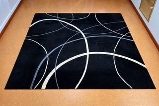 Alfombra negra con diseño de líneas blancas