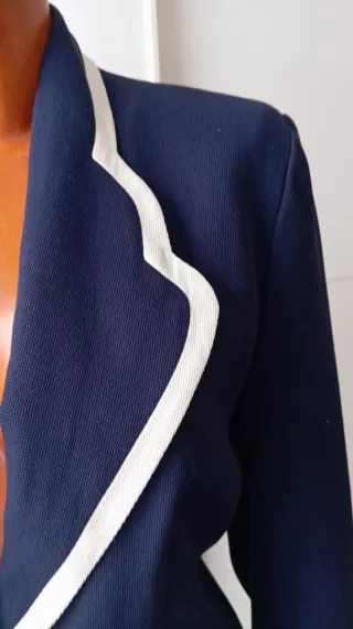 Chaqueta vintage azul con botones blancos.