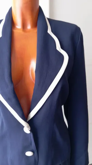 Chaqueta vintage azul con botones blancos.