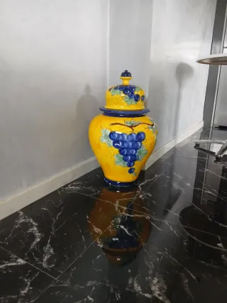 Jarrón de cerámica amarillo con uvas azules