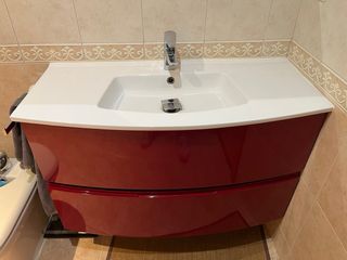 Mueble de baño rojo y blanco, con lavabo y espejo