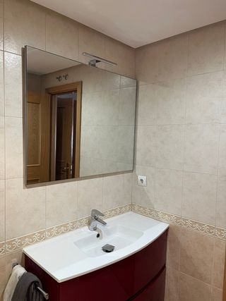 Mueble de baño rojo y blanco, con lavabo y espejo
