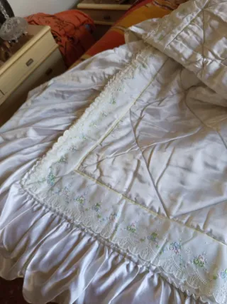 Colcha de cama satinada con volantes .