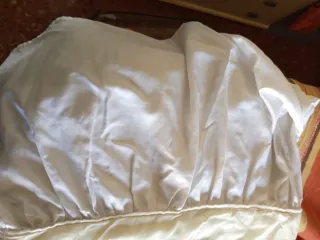 Colcha de cama satinada con volantes .