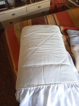 Colcha de cama satinada con volantes .