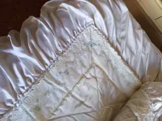 Colcha de cama satinada con volantes .