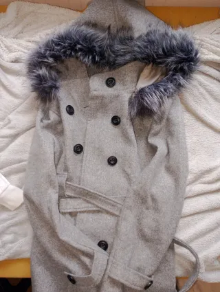 Elegante abrigo gris con capucha de pelo