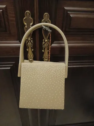 Bolso de mano beige con pedrería