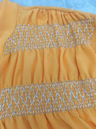 Blusa naranja con detalles dorados