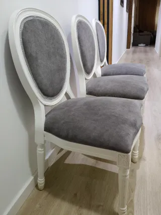 Sillas de madera blancas tapizadas en gris