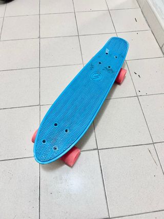 Monopatín azul con ruedas naranjas