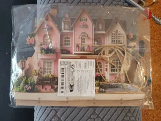 Casa de muñecas rosa de madera y papel