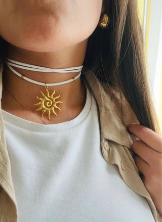 Choker scamosciato bianco con ciondolo sole oro