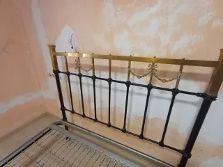 Cama de forja negra y dorada