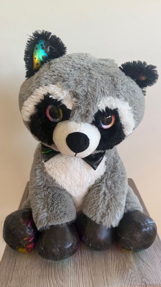 Peluche mapache con pajarita y ojos brillantes