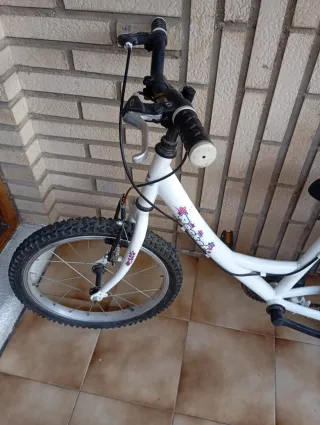 Bicicleta infantil blanca con sillita rosa