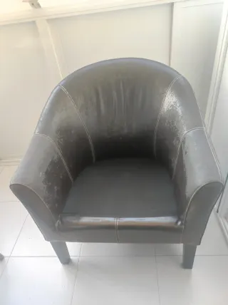 Sillones de piel, madera y mimbre con cojín.