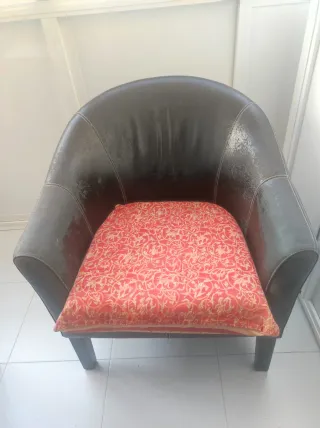 Sillones de piel, madera y mimbre con cojín.