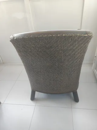 Sillones de piel, madera y mimbre con cojín.