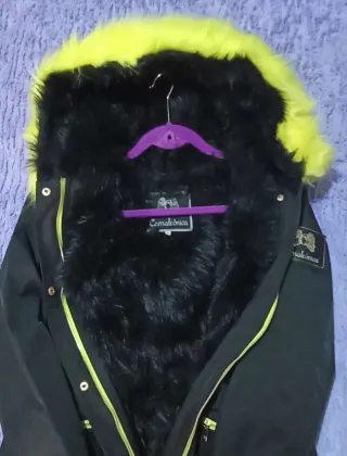 Abrigo Camaleónica negro con capucha de pelo neón.