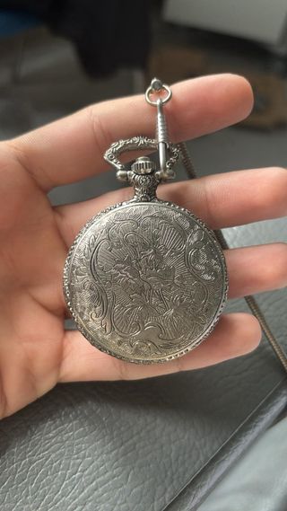 Reloj de bolsillo plateado con águila