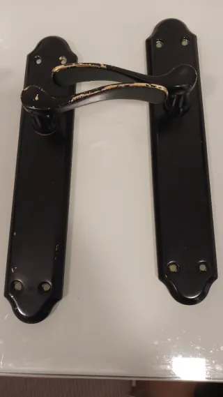 Manivela de puerta dorada, que se pinto de negro.