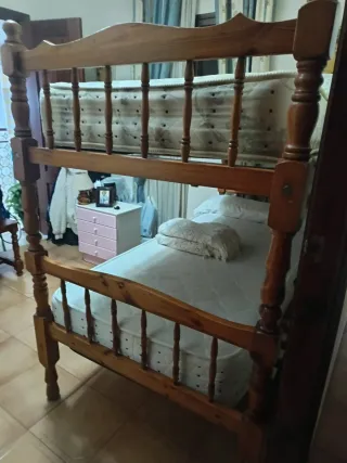 Litera de madera con colchone, almohadas y colchas
