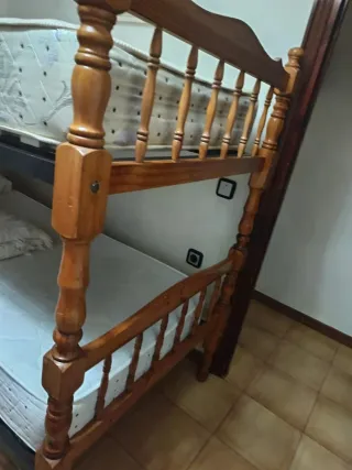 Litera de madera con colchone, almohadas y colchas