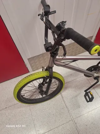 Bicicleta BMX plateada con ruedas amarillas