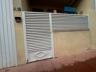 Puerta de hierro y valla blanca