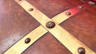 Baúl de cuero y madera con herrajes metálicos