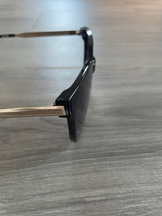 Gafas de sol grandes negras con patillas doradas